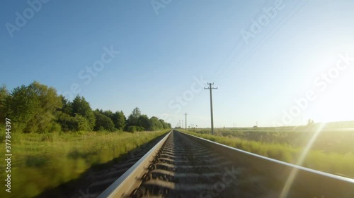 Fast flight close to train tracks in a clear sunny day photo
