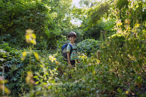 A boy with a backpack walks in the meadow © zhukovvvlad