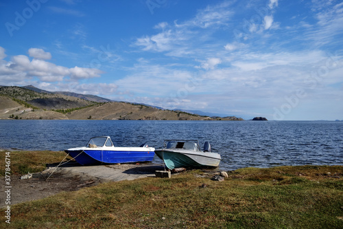 Canvastavla white blue and gray small boats on green grassy shore of bay of lake baikal amon