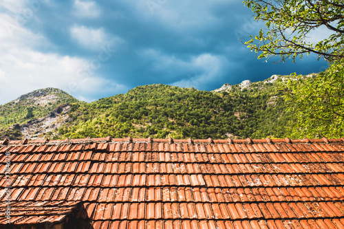 Old red tiles on the roof against the background of mountains - a mountain village in Montenegro © andrey gonchar