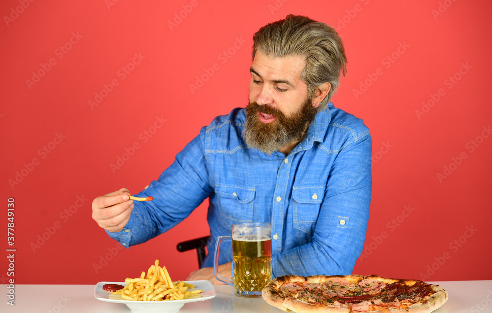Good appetite. Consume alcohol. Enjoy your meal. Beer and food. Dinner at pub. Hungry man drink beer and eat snacks. Bar restaurant. Cheerful man bearded hipster drinking beer. Friday party concept