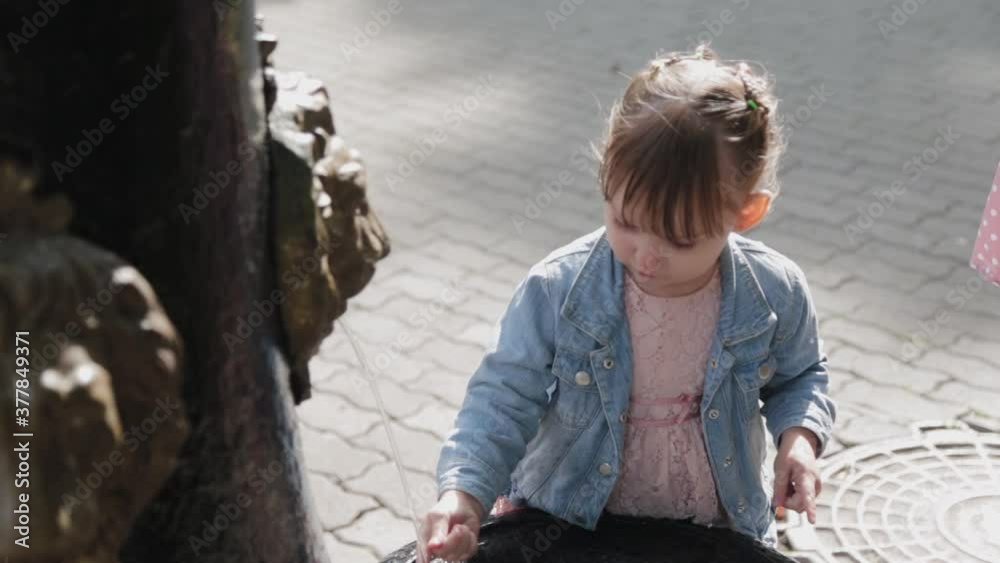 Little girl at the drinking fountain in the park. Little girl at the drinking fountain in the park.
