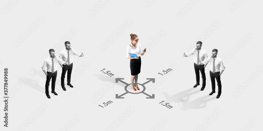 Studio shot of people demonstrating social distancing with arrows indicating the separation. Office workers during coronavirus outbreak with new rules for safety and healthcare. High angle view