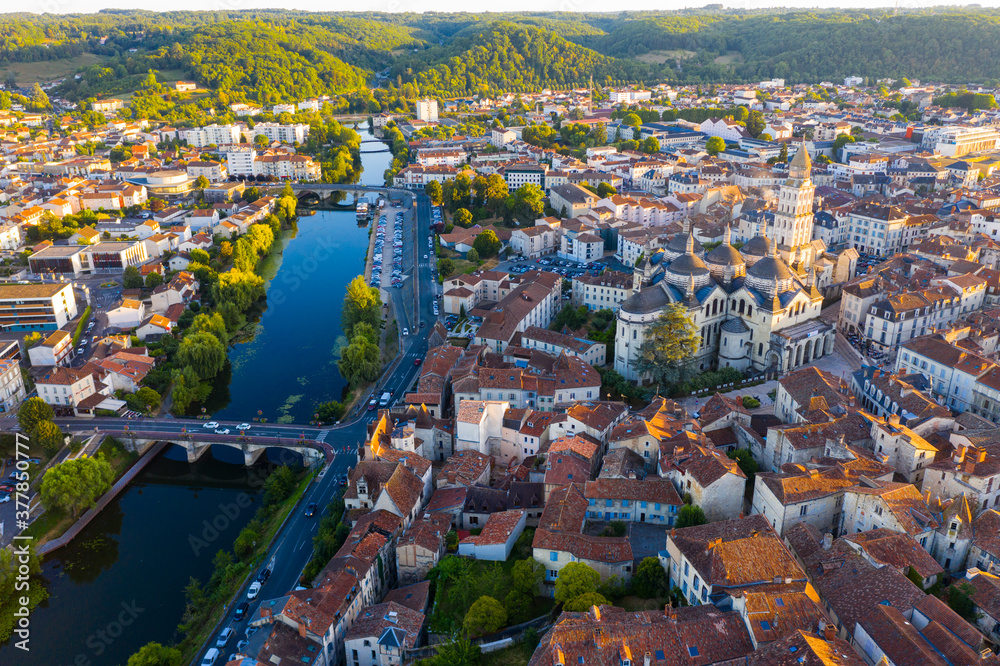 Scenic summer landscape of Perigueux with medieval Catholic Cathedral on bank of Isle river at sunset, France