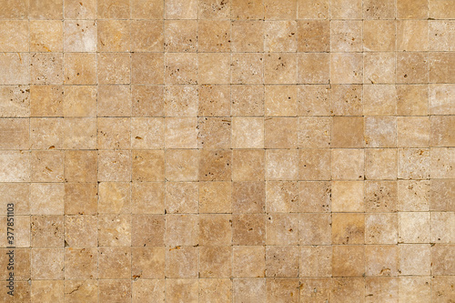 Wall background with Yellow natural sandstone tiles stiched together with clay