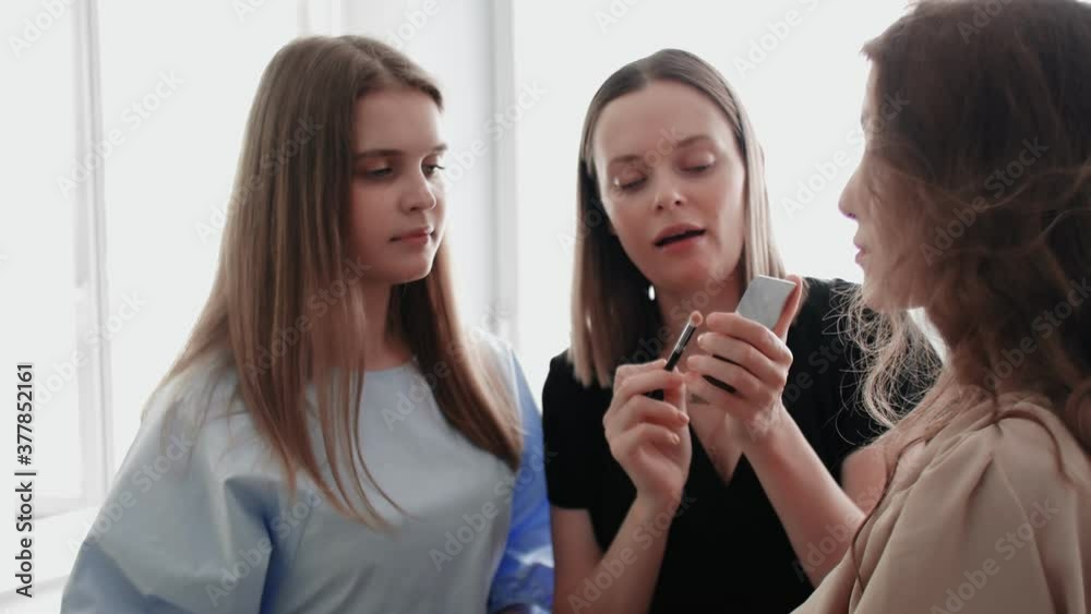 Adult professional teacher visagiste training her student to become makeup artist at master class in beauty salon. Adult professional teacher visagiste training her student to become makeup artist at master class in beauty salon.