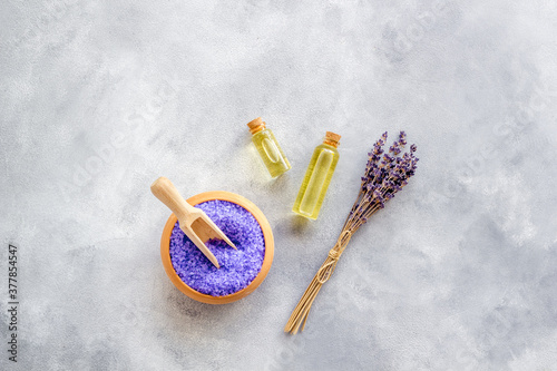Lavender spa set. Violet bath salt, essence oil on grey stone background