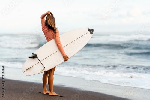 surf girl looking out at blue ocean summer time
