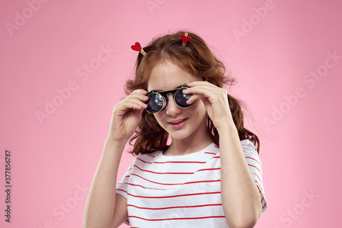 Cute girl sunglasses striped t-shirt lifestyle fun style pink background © SHOTPRIME STUDIO