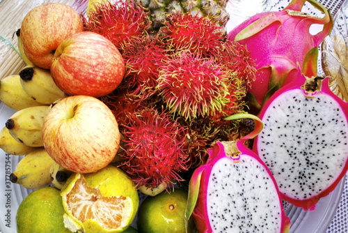 Tropical Fruits, such as pineapple, banana, rambutan, orange and dragon fruit, are prepared for Buddhism worship. Tropical fruits and Buddhism worship concept. photo