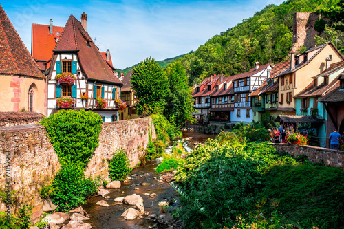Colorful facades and flowers overlooking the river in the village of Kaysersberg in Alsace, France