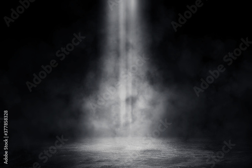 Empty space of Studio dark room with spot lighting and fog or mist on concrete floor in black background. 