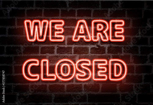 We are closed  red neon light entrance sign on brick wall photo