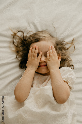 Child covering her eyes with her hands