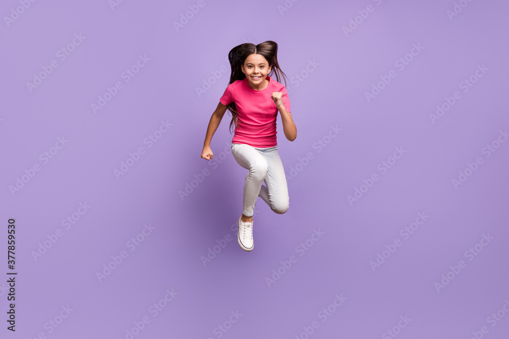 Full length body size photo of jumping high happy smiling schoolgirl hurrying up running fast isolated on purple color background