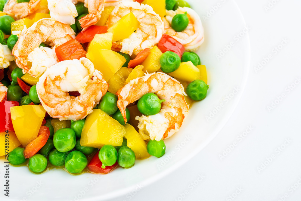 Fried shrimps with peas on a dish on white background