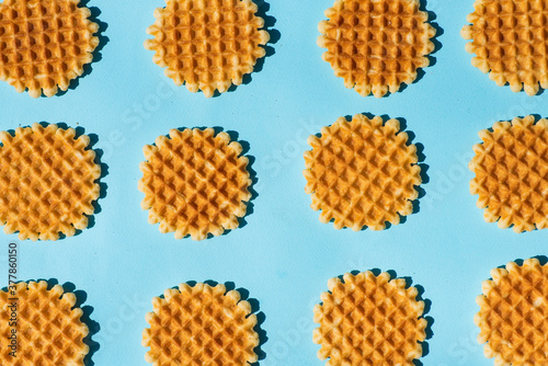 Belgium style waffles on blue background pattern flat lay