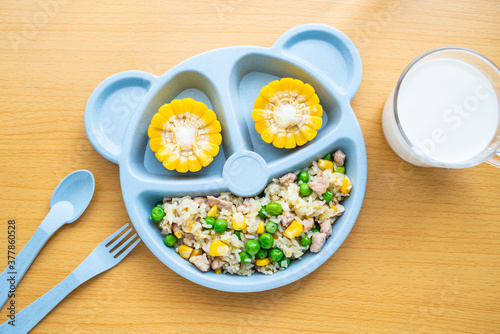 A plate of fried rice with diced meat for children's nutrition meal on the table