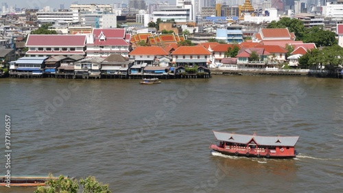 Oriental boat floating on river in Krungthep city. Modern transport vessel floating on calm Chao Praya river on sunny day in Bangkok near chinatown. Panorama