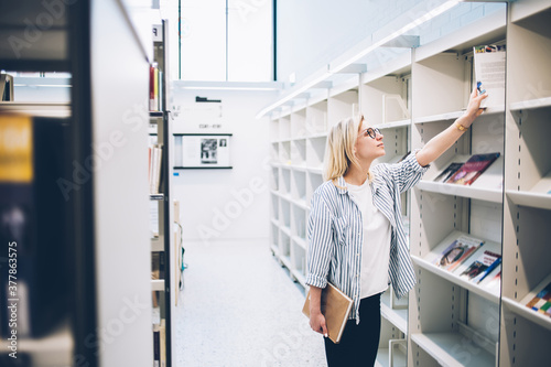 Female student choosing book in library