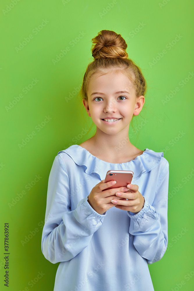 pretty caucasian kid girl using smartphone, chatting with friends, typing. isolated on green background, studio shoot pretty caucasian kid girl using smartphone, chatting with friends, typing. isolated on green background, studio shoot
