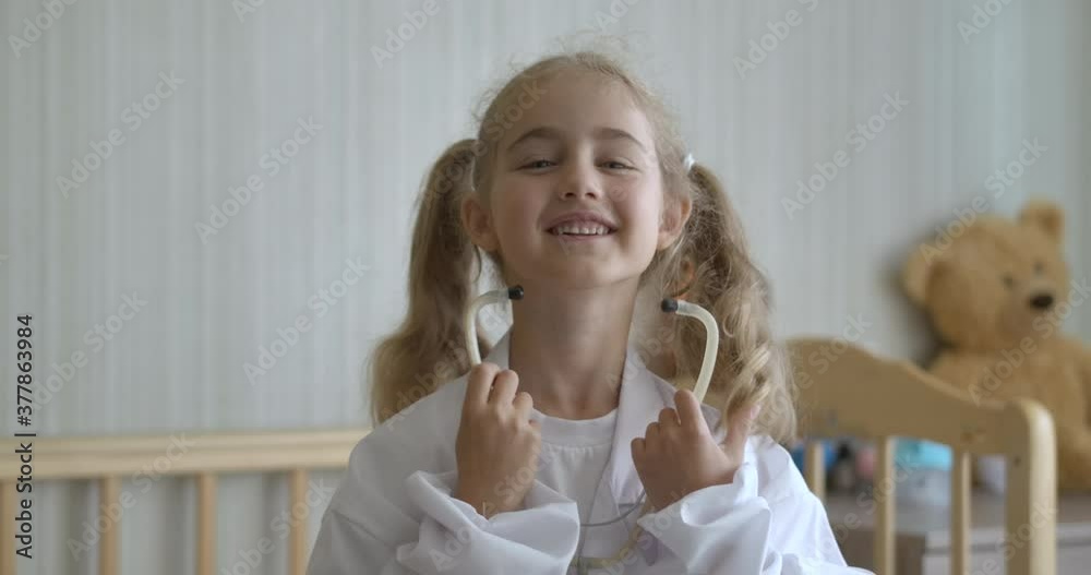 Portrait Cute Little Kid Girl Wear Medical Uniform Playing at Hospital at home. Creative Funny Little Child Girl Wear Medical Uniform Stethoscope Playing Game as Doctor, Pretending Medic Nurse. Portrait Cute Little Kid Girl Wear Medical Uniform Playing at Hospital at home. Creative Funny Little Child Girl Wear Medical Uniform Stethoscope Playing Game as Doctor, Pretending Medic Nurse.