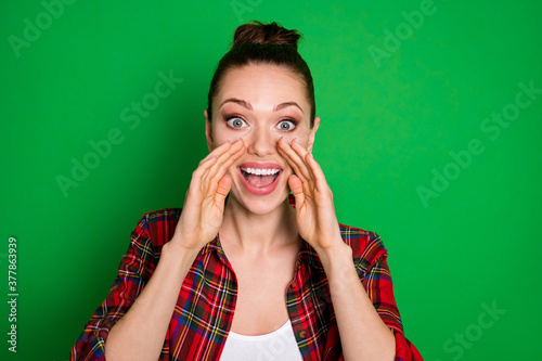 Close-up portrait of her she nice-looking attractive lovely pretty glad cheerful cheery girl in checked shirt saying good news advert isolated on bright vivid shine vibrant green color background