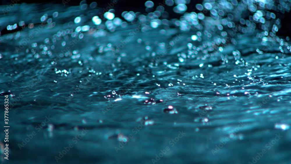 Beautiful blue water flowing and bubbly in dark background - graphics