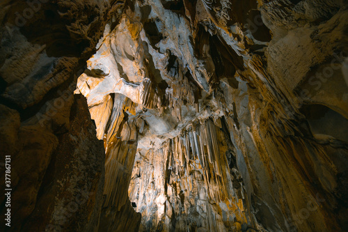 Fototapeta Naklejka Na Ścianę i Meble -  The interior of the cave. Ancient formations of stone. Touristic hiking route. Concept of excursions and attractions. (Cüceler mağarası) Tırılar, Sapadere, Alanya