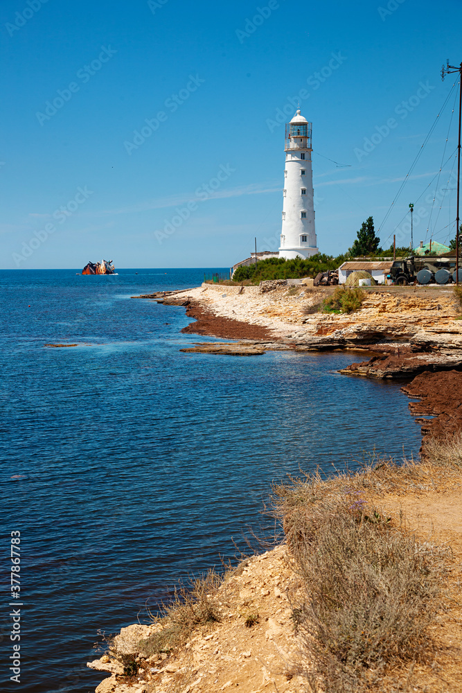 Blue sea lanscape with white lighthouse on foreland