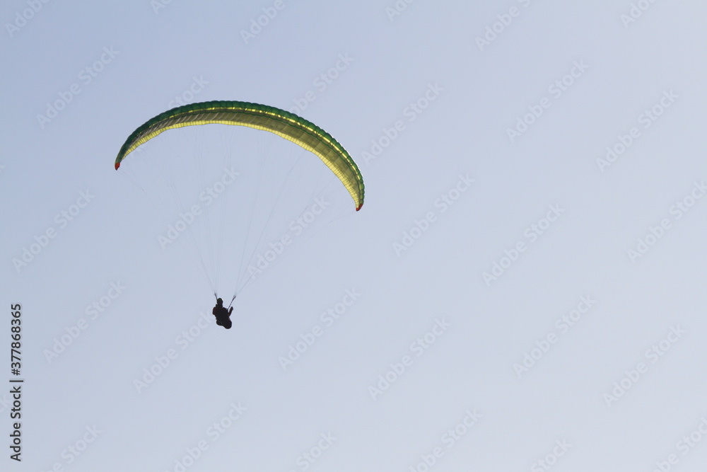 Adventure sports. Person practicing paragliding on the cliffs of the coast. Black and white photo. Adventure sports. Person practicing paragliding on the cliffs of the coast. Black and white photo.