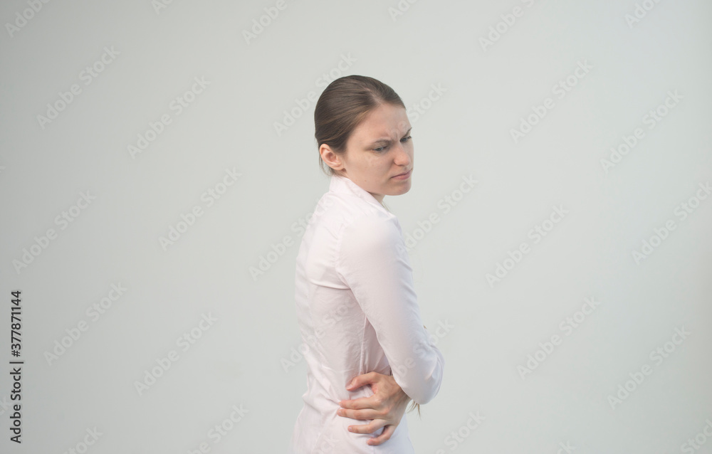 Attractive teenage girl suffers from backache. All on white background Attractive teenage girl suffers from backache. All on white background