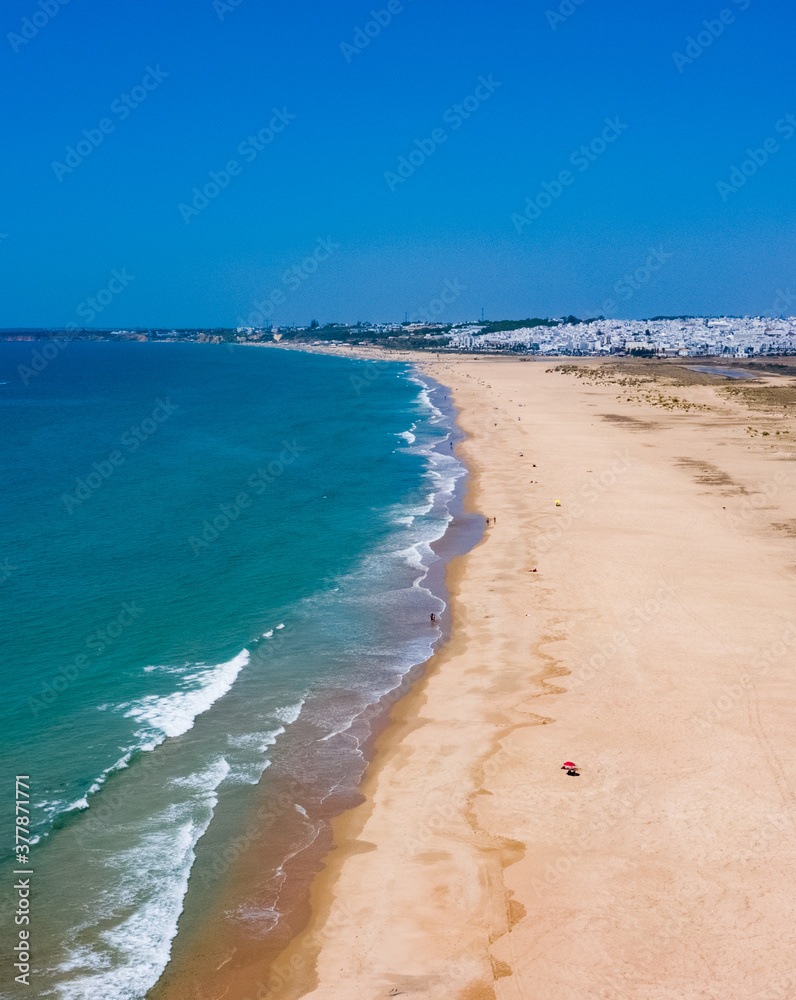 Vertical image of aerial drone view of endless sand beach between Conil and El Palmar in south Spain at the Atlantic coast