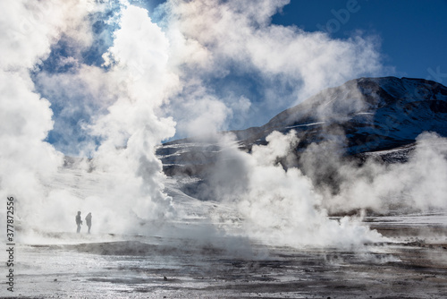 El Tatio geysers in Chile, Silhouettes of tourists among the steams and fumaroles at sunrise photo