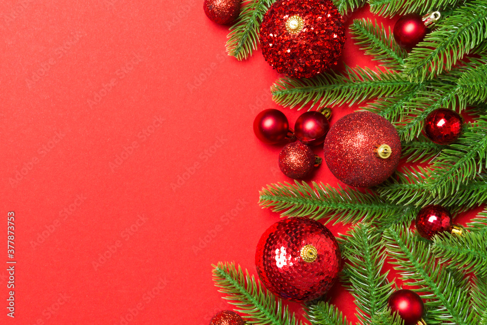 Christmas composition made of fir tree, balls and different decorations on colorful background. Top view of New Year Advent concept with empty space for your design