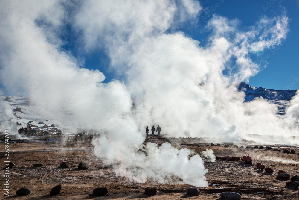 El Tatio geysers in Chile, Silhouettes of tourists among the steams and fumaroles at sunrise