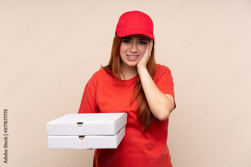 Pizza delivery teenager girl holding a pizza over isolated background unhappy and frustrated with something. Negative facial expression Pizza delivery teenager girl holding a pizza over isolated background unhappy and frustrated with something. Negative facial expression