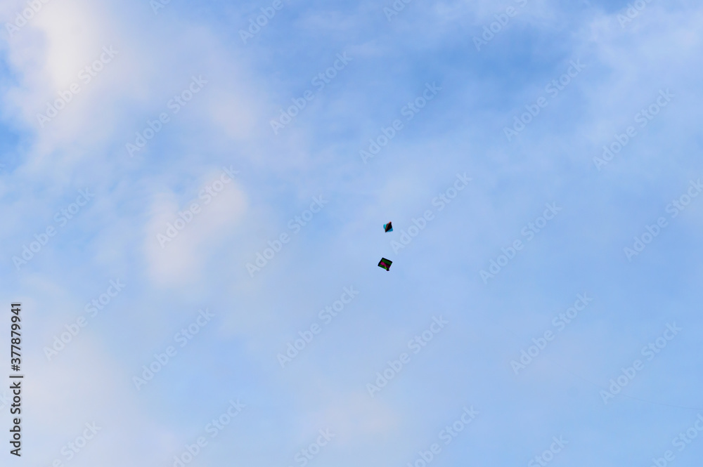 Kite flying in the sky. Kites flying picture with blue sky and white clouds. Photography in the eve of Vishwakarma Puja in Kolkata. Low angel View. Motion Blur. Kite flying in the sky. Kites flying picture with blue sky and white clouds. Photography in the eve of Vishwakarma Puja in Kolkata. Low angel View. Motion Blur.