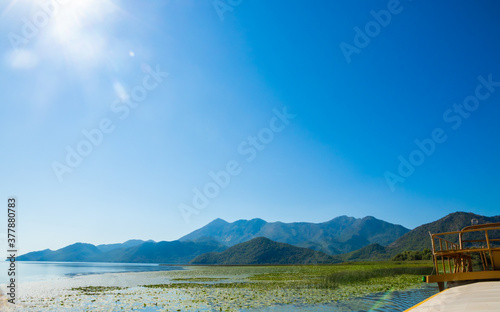 In the middle of the huge Skadar Lake on a pleasure boat, breathtaking landscapes and mountains, a bright sunny day in Montenegro