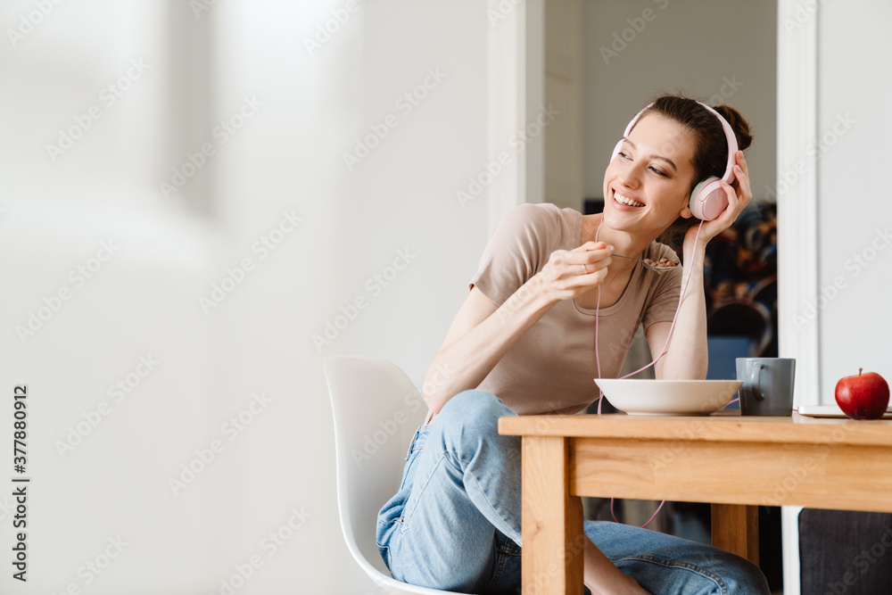 Image of cheerful girl working while having breakfast Image of cheerful girl working while having breakfast