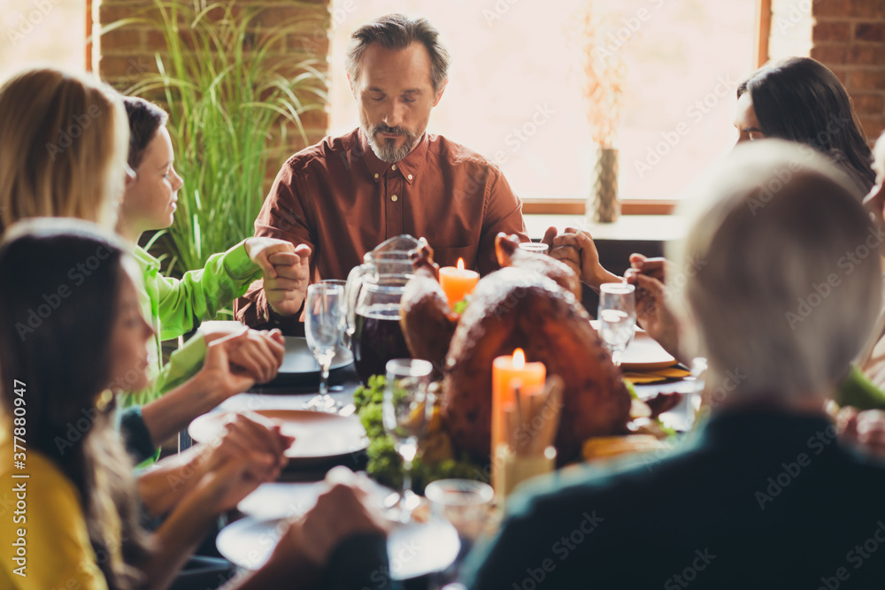 Full family ask god grace prayer hold hands thanks giving dinner tradition sit table turkey dish living room indoors Full family ask god grace prayer hold hands thanks giving dinner tradition sit table turkey dish living room indoors