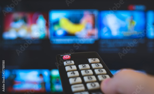 Male hand with remote control pointing on Smart TV.