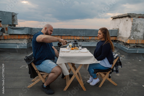 Lovers on the roof sit at a table.