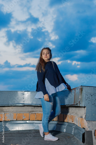 Beautiful young woman on the rooftop in the evening.