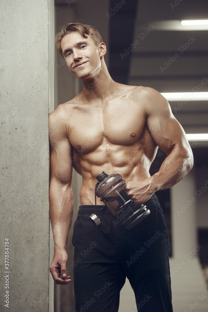 Fototapeta premium Bodybuilder drinking water after fitness workout