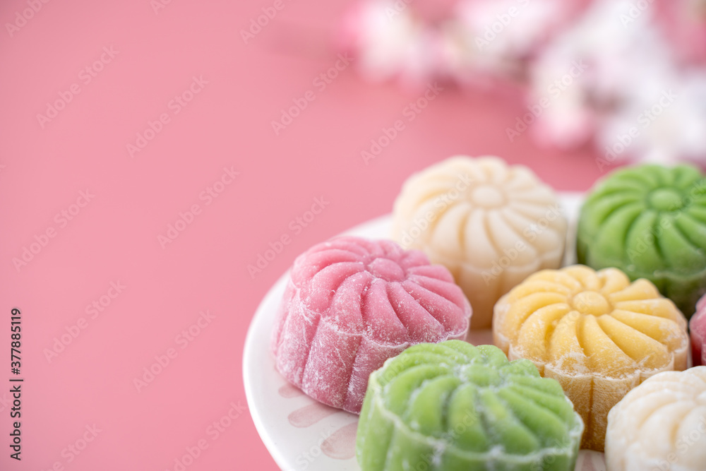 Colorful snow skin moon cake, sweet snowy mooncake, traditional savory dessert for Mid-Autumn Festival on pastel pale pink background, close up, lifestyle. Colorful snow skin moon cake, sweet snowy mooncake, traditional savory dessert for Mid-Autumn Festival on pastel pale pink background, close up, lifestyle.