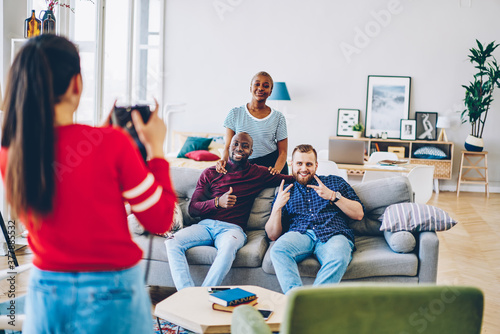 Cheerful diverse friends posing for picture in living room