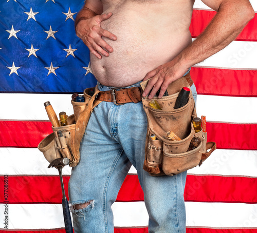 Foto Male carpenter with big fat stomach wearing old, leather tool belt with hand too