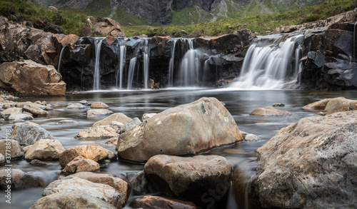 Fairy pools waterfalls surrounded by mountains during a cloudy day on the Isle of Skye in Scotland