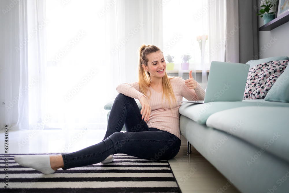 Happy young woman sitting at home using laptop computer to video chat Happy young woman sitting at home using laptop computer to video chat